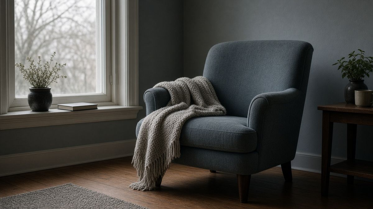 Leerer Sessel mit Decke am Fenster — Erholung im Grippeverlauf
